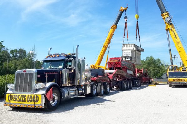 A transformer being offloaded from a 19 axle trailer.