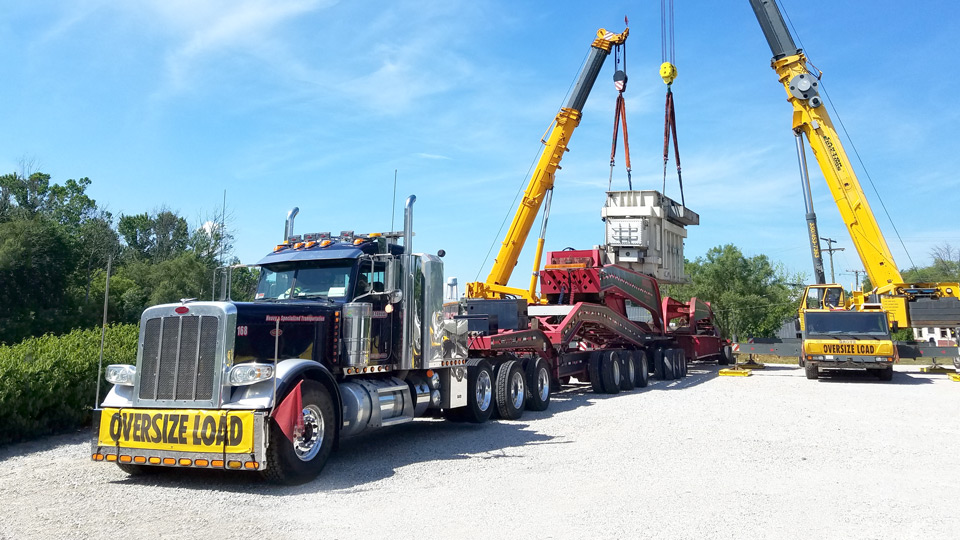 A transformer being offloaded from a 19 axle trailer.