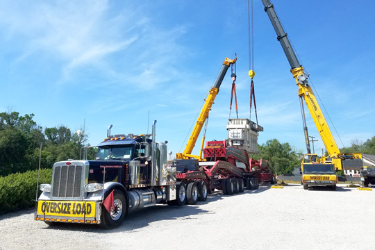 A transformer being offloaded from a 19 axle trailer.