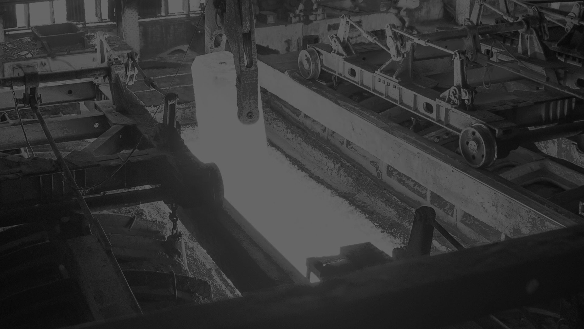 A darkened black and white image of a heat treat furnance.