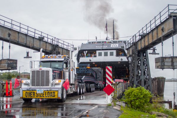 A 20 axle trailer being backed into the underbelly of a ferry.