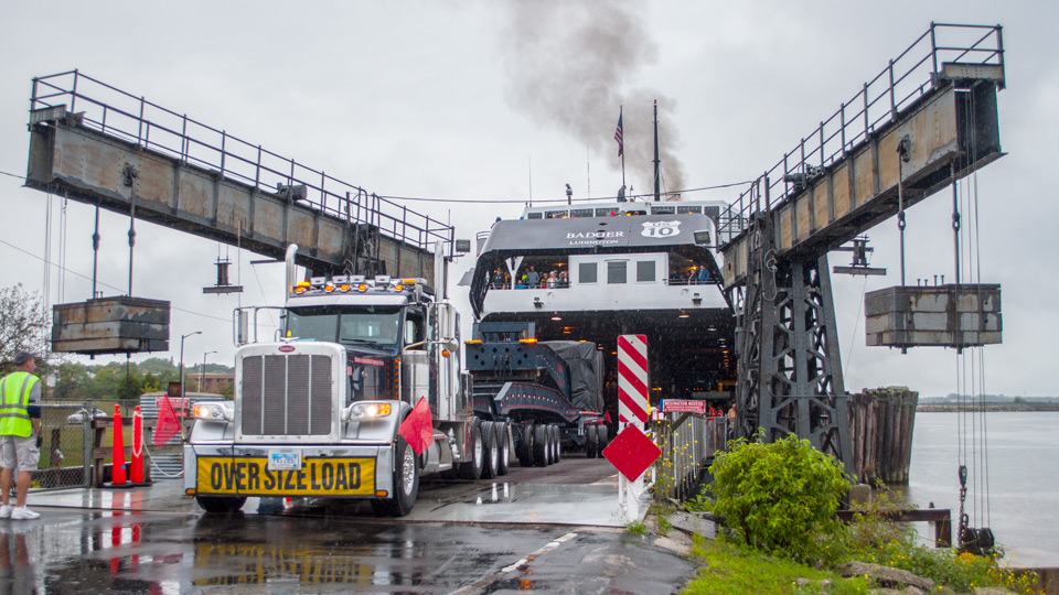 A 20 axle trailer being backed into the underbelly of a ferry.