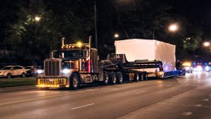A control building being shipped in the middle of the night in Downtown Chicago.