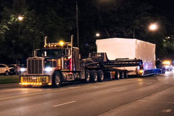 A control building being shipped in the middle of the night in Downtown Chicago.