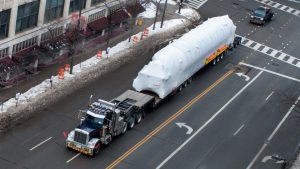 A oversize load taking up all lanes of a city street.