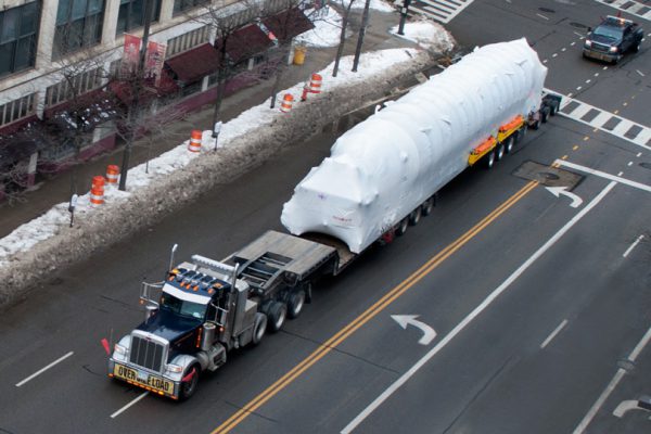A oversize load taking up all lanes of a city street.