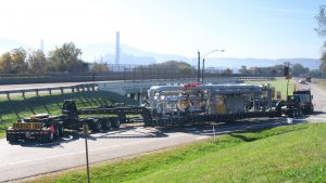 A perimeter 13 axle trailer negotiates a turn using it's rear steering capabilities.