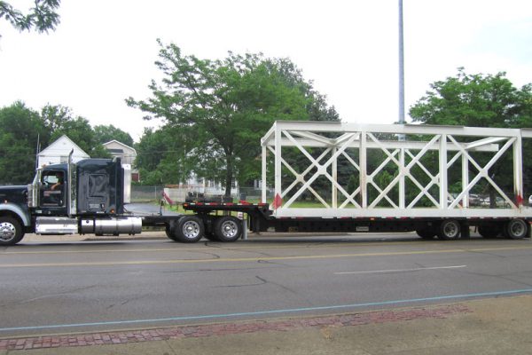 A standard stepdeck hauling a oversize load bridge section.