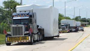 A group of 3 oversize loads parked along the side of a rest area in Illinois.