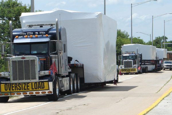 A group of 3 oversize loads parked along the side of a rest area in Illinois.